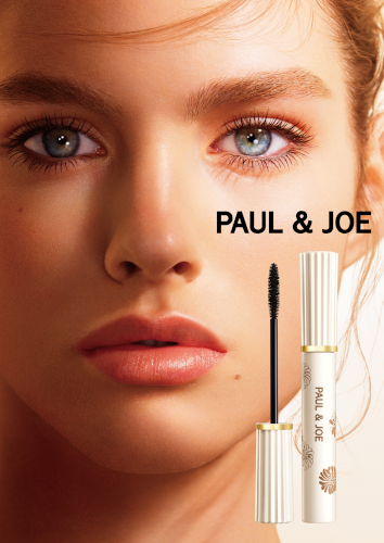 Gros plan sur un maquillage des yeux r&eacute;alis&eacute; avec le mascara noir Paul &amp; Joe. Le visuel montre des cils parfaitement d&eacute;finis, allong&eacute;s et volumineux sur un mannequin aux yeux clairs. &Agrave; c&ocirc;t&eacute; du visage, le flacon de mascara blanc orn&eacute; de motifs floraux iconiques de la marque et sa brosse applicatrice.
